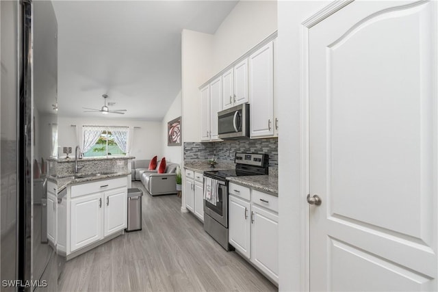 kitchen with light stone countertops, white cabinetry, sink, and appliances with stainless steel finishes