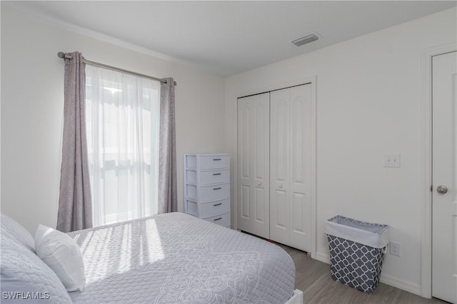 bedroom with light hardwood / wood-style flooring and a closet