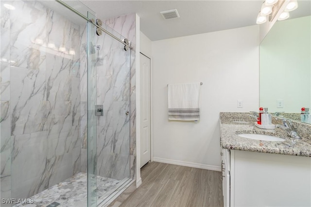 bathroom featuring a shower with shower door, wood-type flooring, and vanity