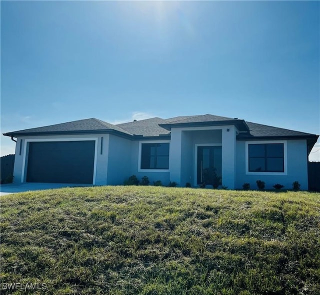 ranch-style house featuring a garage and a front lawn