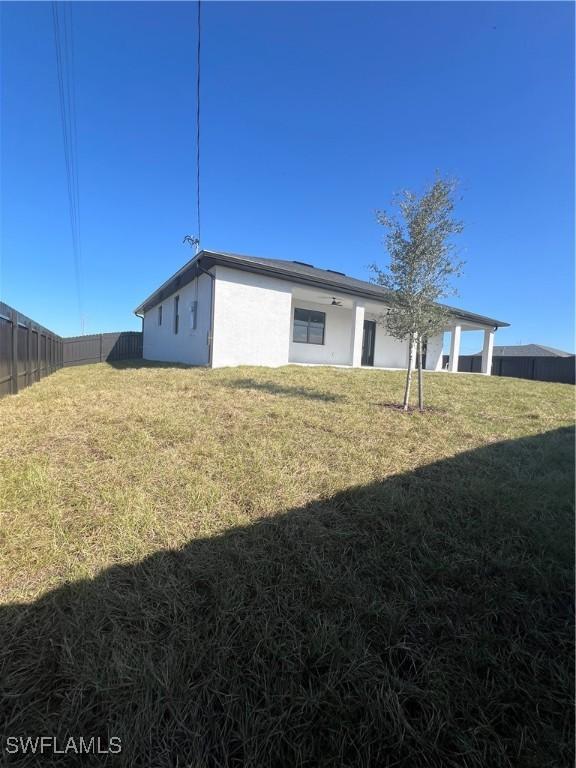 rear view of property featuring a yard