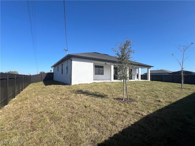 back of house featuring a lawn