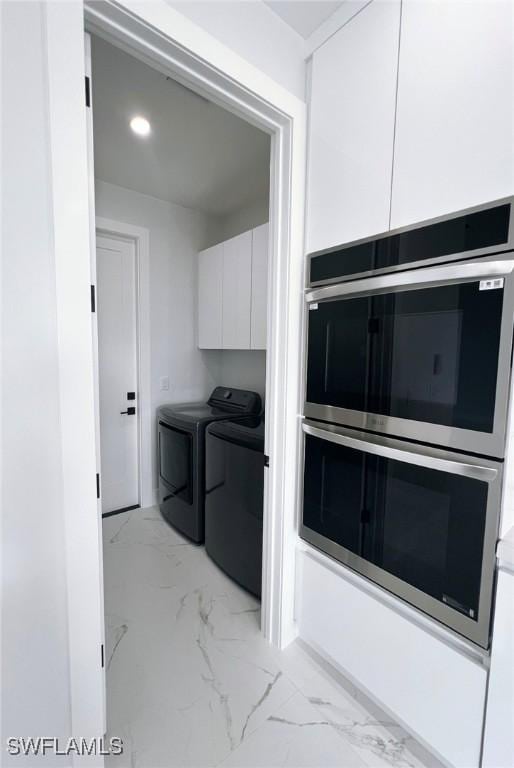 washroom with cabinets and washer and clothes dryer