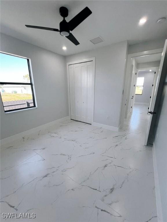 unfurnished bedroom with ceiling fan and a closet