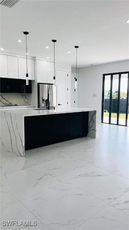 kitchen featuring sink, white cabinets, hanging light fixtures, and stainless steel refrigerator with ice dispenser