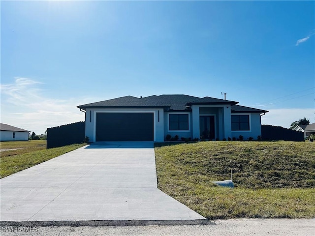 ranch-style home featuring a front lawn and a garage