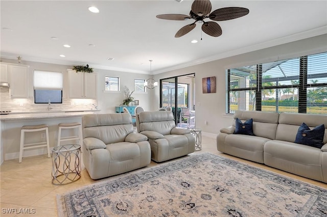 living room with ceiling fan with notable chandelier, sink, light tile patterned floors, and ornamental molding