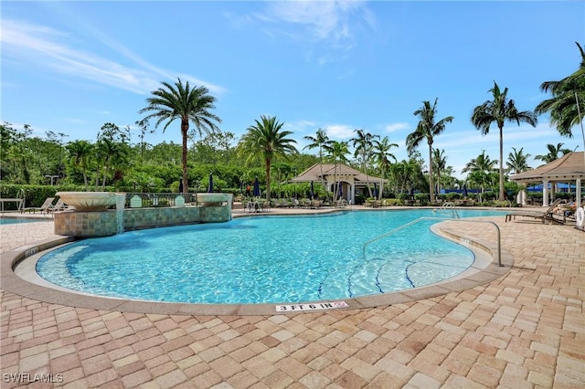 view of swimming pool featuring pool water feature and a patio area