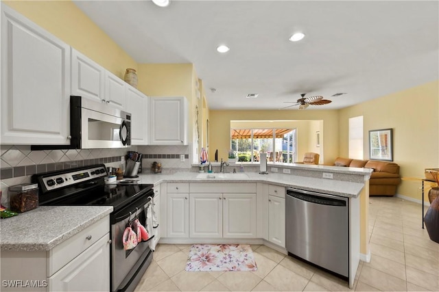 kitchen featuring kitchen peninsula, appliances with stainless steel finishes, white cabinetry, and ceiling fan