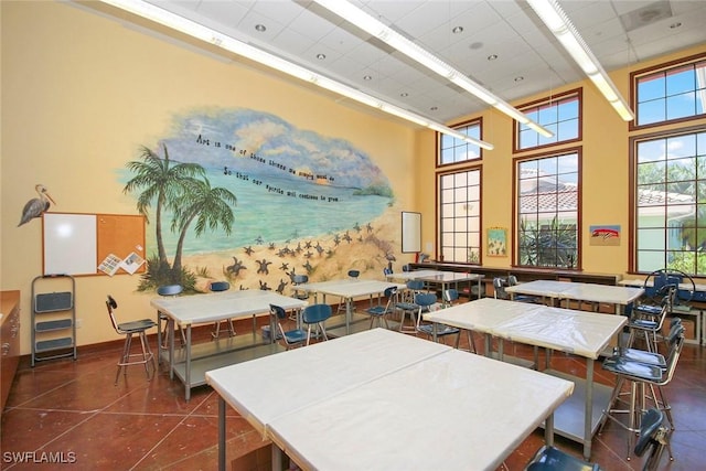 interior space with dark tile patterned floors and a high ceiling