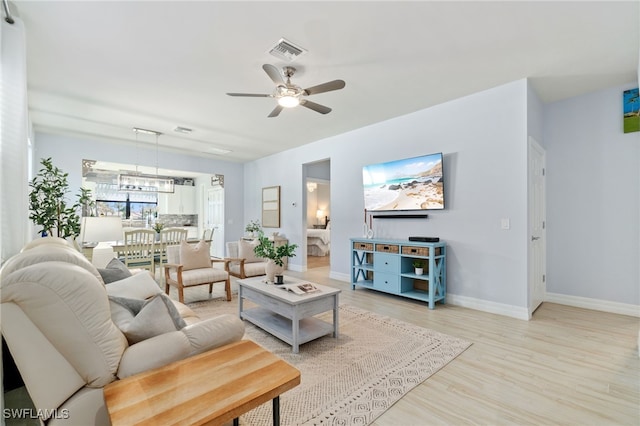 living room with ceiling fan and light hardwood / wood-style flooring