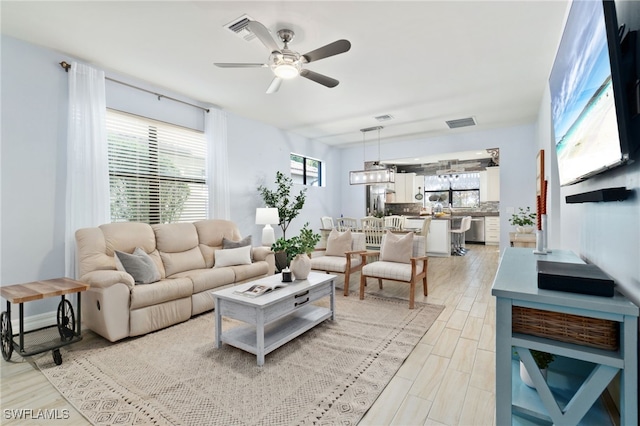 living room with ceiling fan and light wood-type flooring