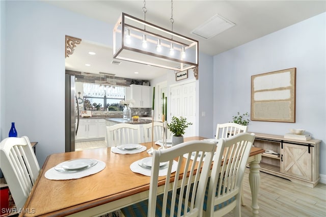 dining room featuring sink and light hardwood / wood-style flooring