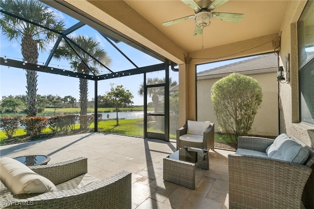 view of patio with a lanai, ceiling fan, and a water view