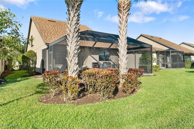 rear view of property featuring a yard and a lanai