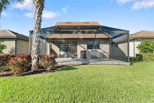 rear view of property featuring a lanai, a patio area, a lawn, and area for grilling