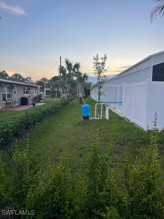 yard at dusk featuring a patio