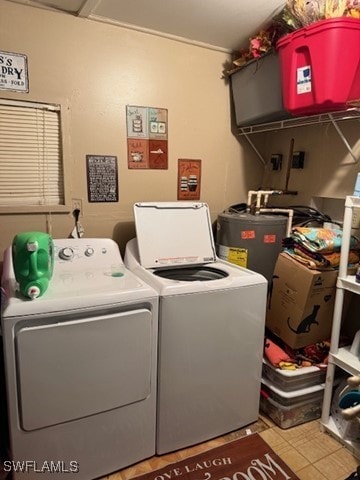 washroom featuring electric water heater and washer and clothes dryer