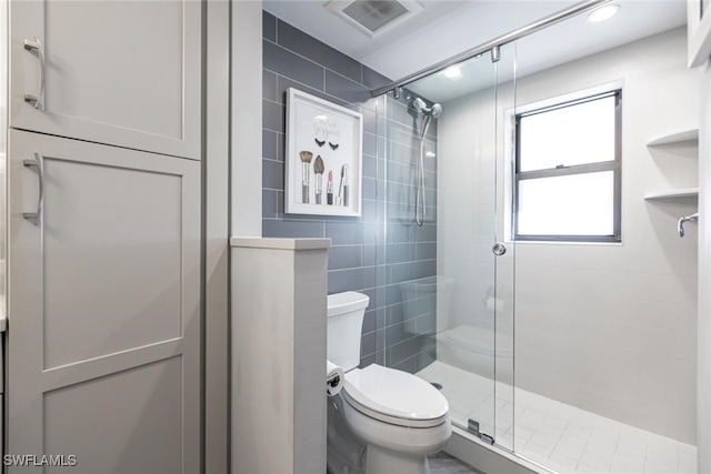 bathroom with toilet, walk in shower, and tile walls