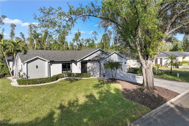 ranch-style home featuring a garage and a front lawn