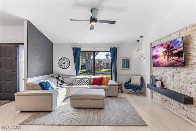 living room featuring light hardwood / wood-style flooring, vaulted ceiling, and ceiling fan