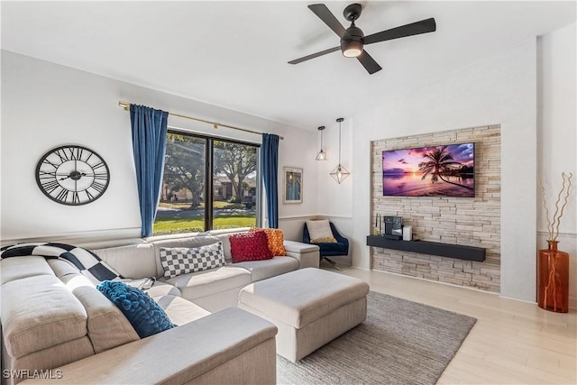 living room with ceiling fan, vaulted ceiling, and light hardwood / wood-style flooring