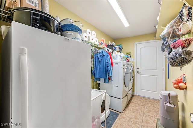 clothes washing area featuring washer and clothes dryer and light tile patterned flooring