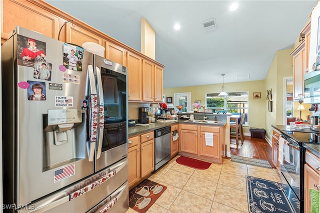 kitchen with kitchen peninsula, appliances with stainless steel finishes, sink, light tile patterned floors, and decorative light fixtures