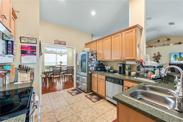 kitchen featuring appliances with stainless steel finishes, sink, light tile patterned floors, a notable chandelier, and lofted ceiling