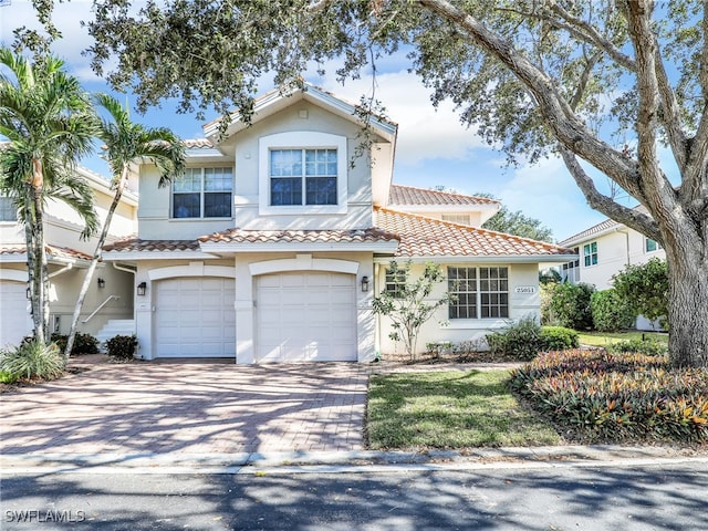 25051 Ballycastle Ct Unit 102, Bonita Springs, FL 34134 - view of front of property featuring a garage, a tiled roof, stucco siding, and decorative driveway