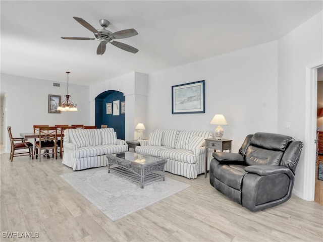 25051 Ballycastle Ct Unit 102, Bonita Springs, FL 34134 - living area with a ceiling fan, arched walkways, light wood finished floors, and a chandelier