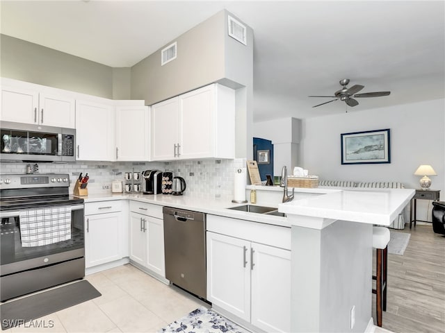 25051 Ballycastle Ct Unit 102, Bonita Springs, FL 34134 - kitchen featuring stainless steel appliances, backsplash, a peninsula, and ceiling fan