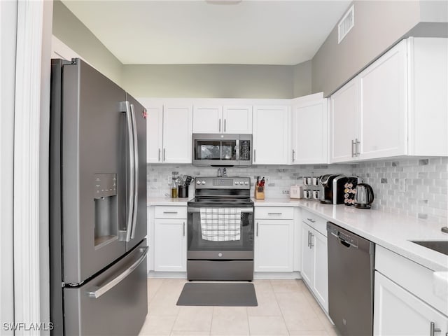 25051 Ballycastle Ct Unit 102, Bonita Springs, FL 34134 - kitchen featuring stainless steel appliances, light tile patterned flooring, and white cabinetry