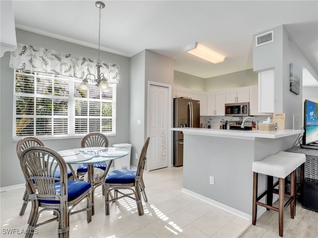 25051 Ballycastle Ct Unit 102, Bonita Springs, FL 34134 - kitchen featuring stainless steel appliances, a chandelier, light countertops, tasteful backsplash, and a peninsula