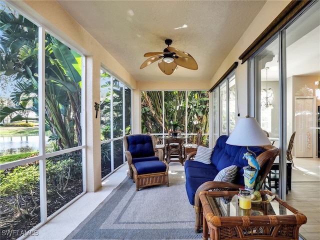 sunroom with a water view, a wealth of natural light, and ceiling fan