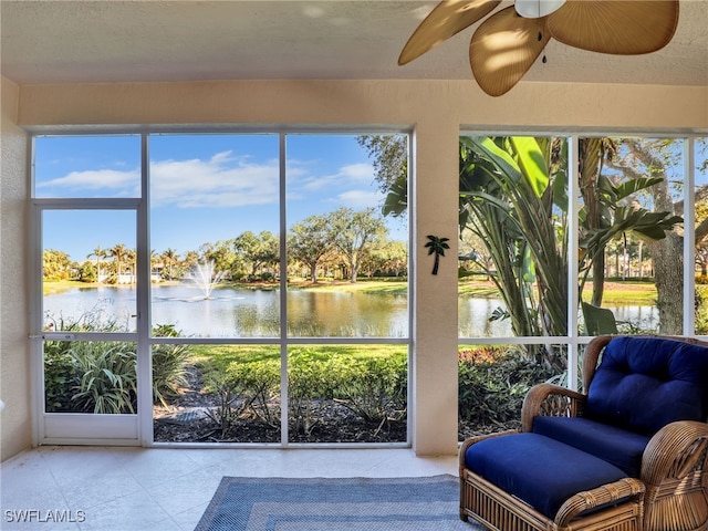 sunroom / solarium featuring ceiling fan, a water view, and a wealth of natural light