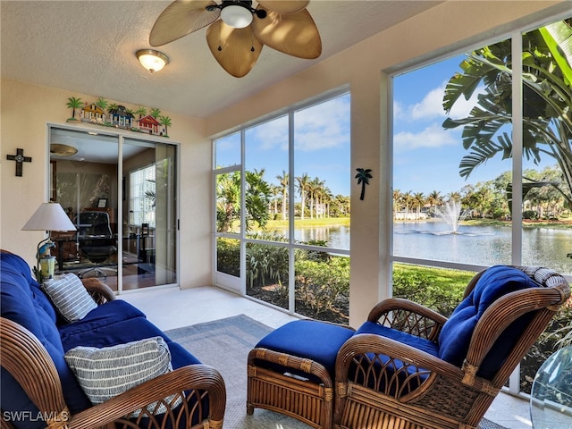 sunroom featuring a water view and ceiling fan