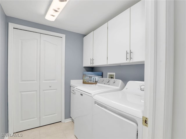 laundry area with cabinets, light tile patterned floors, and washer and dryer