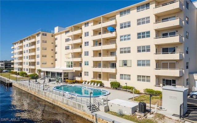 view of property featuring a water view and a community pool