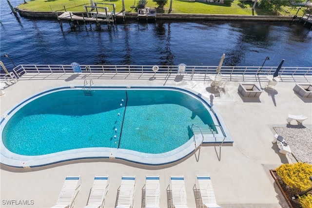 view of pool with a water view and a patio