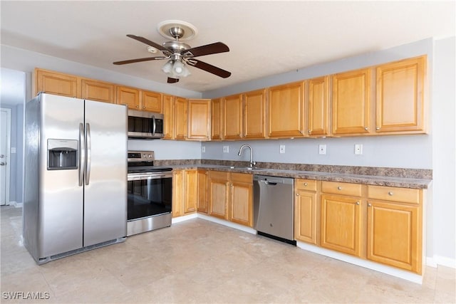 kitchen with appliances with stainless steel finishes, ceiling fan, and sink