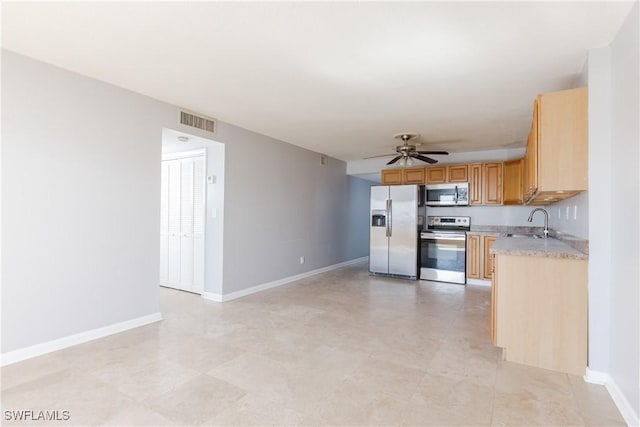 kitchen with appliances with stainless steel finishes, ceiling fan, and sink