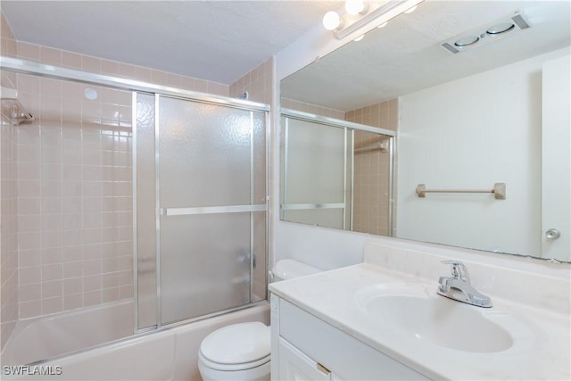 full bathroom with vanity, toilet, and bath / shower combo with glass door