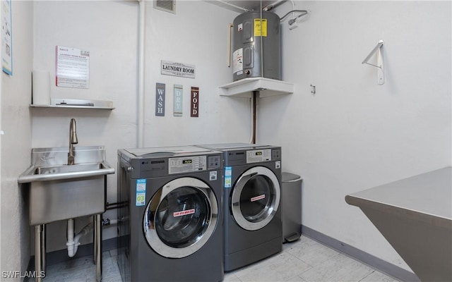 washroom featuring electric water heater, sink, and washer and dryer