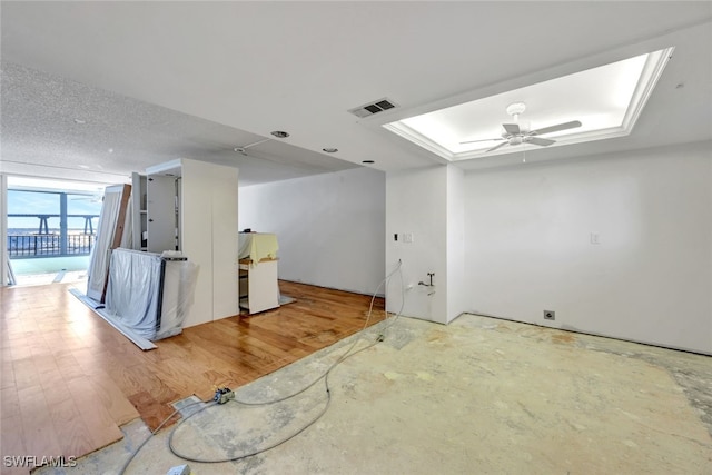 empty room featuring hardwood / wood-style floors, a tray ceiling, and ceiling fan