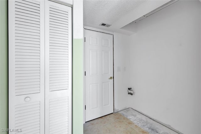 interior space featuring light tile patterned floors and a textured ceiling