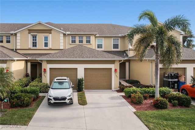 view of front facade featuring a garage, concrete driveway, a shingled roof, and stucco siding