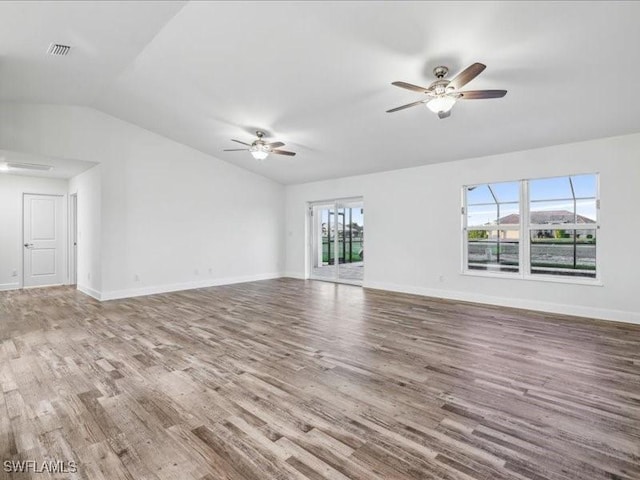 unfurnished living room with a wealth of natural light, hardwood / wood-style floors, ceiling fan, and vaulted ceiling