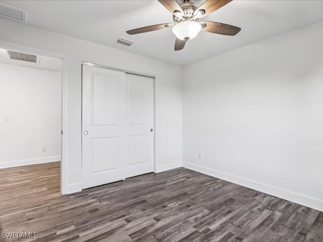 unfurnished bedroom featuring ceiling fan, dark hardwood / wood-style flooring, and a closet