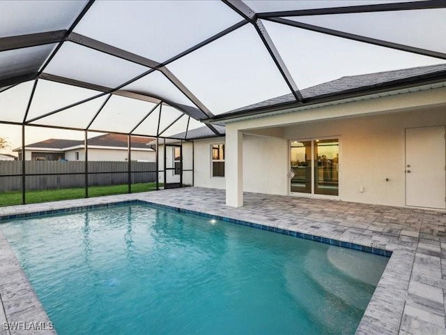 view of swimming pool featuring glass enclosure and a patio area